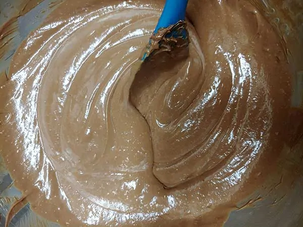 Mixing cheesecake batter with rubber spatula.