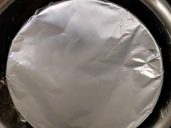 Push pan covered in aluminum foil in Instant Pot.