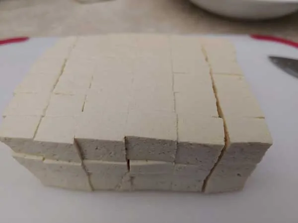 Block of tofu cut into small cubes.