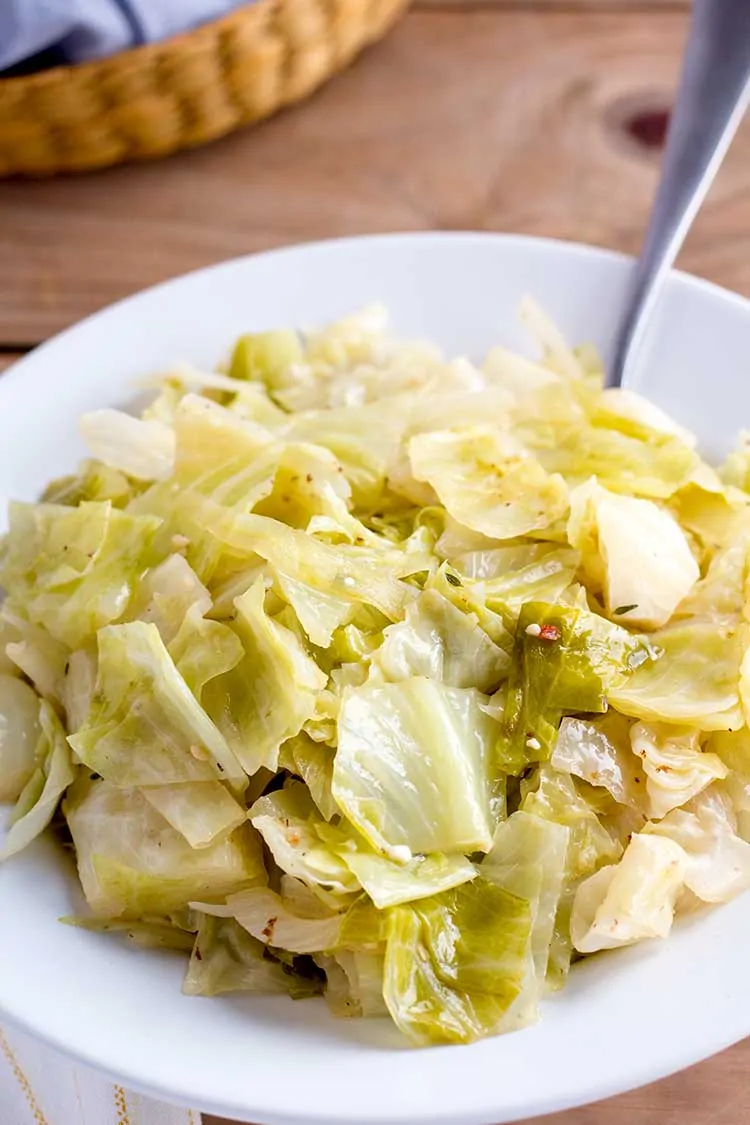 Instant Pot cabbage in white bowl with serving spoon.