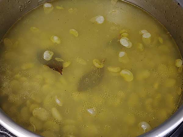 Cooked baby lima beans in pot.