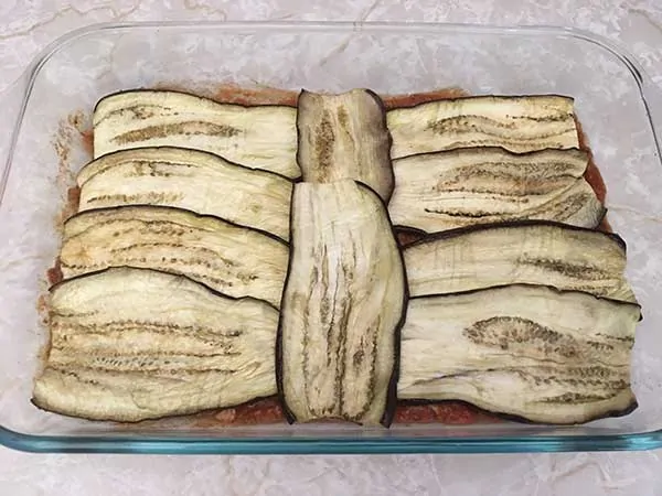Layer of cooked eggplant noodles in casserole dish.