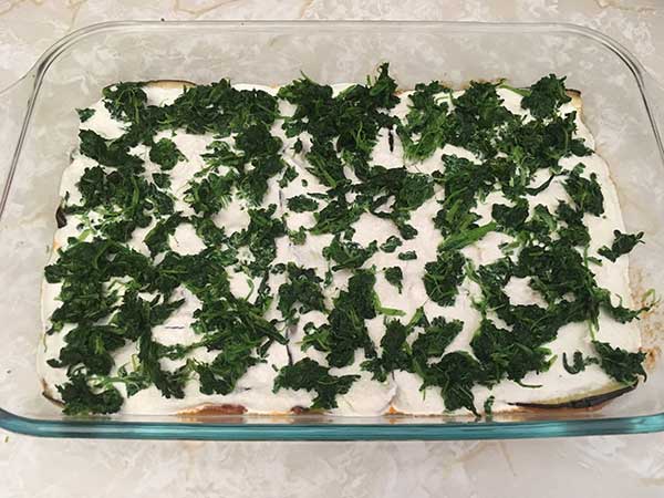 Layer of spinach in casserole dish.