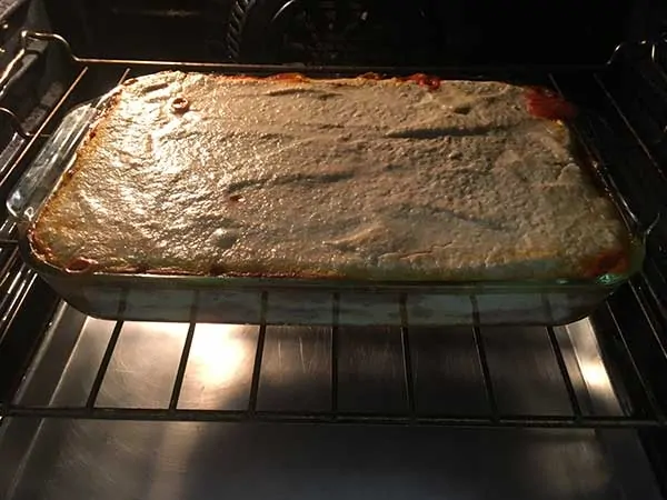 Uncooked lasagna baking in oven.