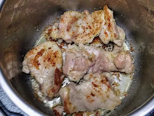 Boneless skinless chicken thighs sautéing in Instant Pot.