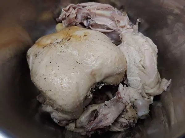Whole cooked chicken in large mixing bowl.