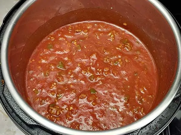 Ground beef and crushed tomatoes in Instant Pot.