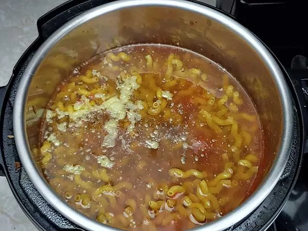 Chicken broth over pasta and tomato sauce.