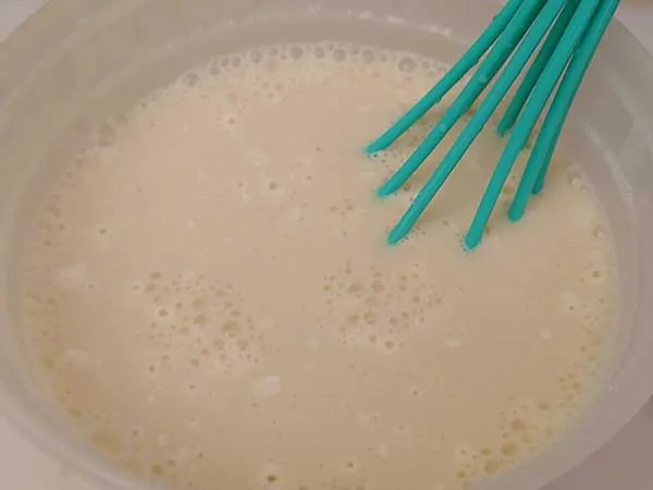 Mixing soy milk and cornstarch in plastic bowl.