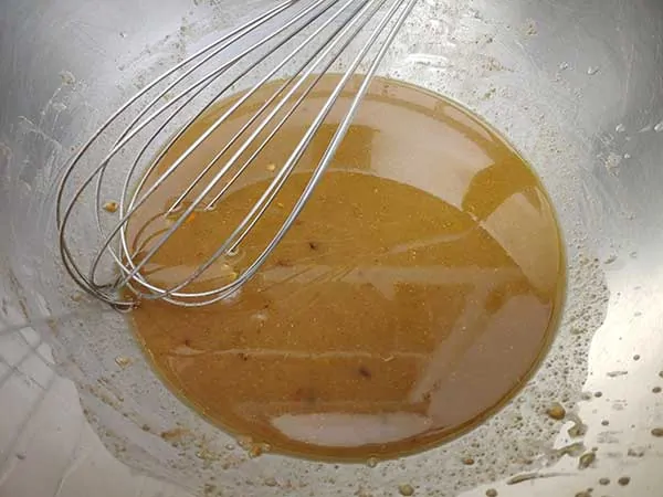 Vinaigrette with whisk in mixing bowl.
