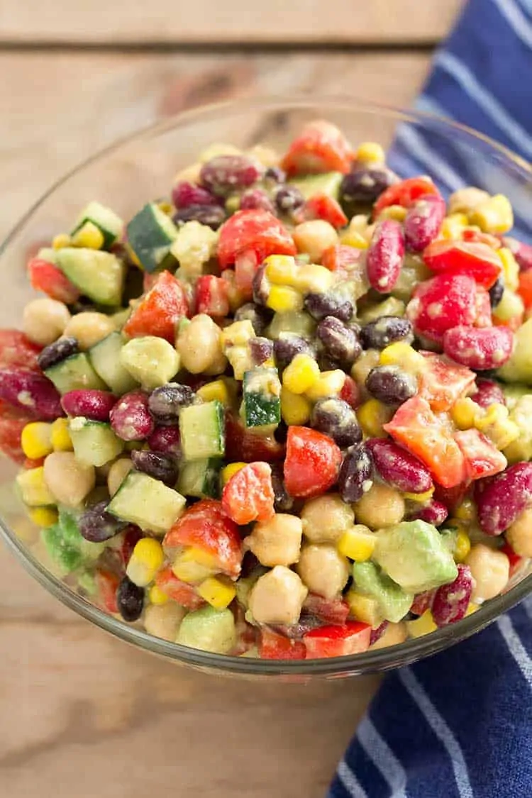Fiesta bean salad in glass bowl with blue linen.