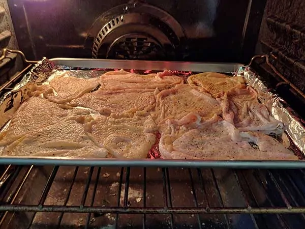 Chicken skins on baking sheet in oven.