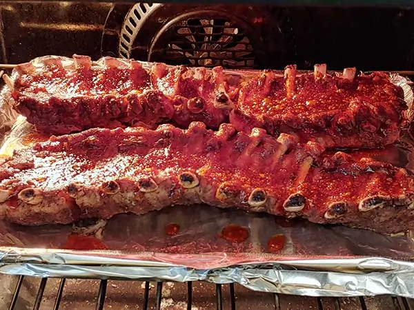 ribs with sauce broiling in oven.