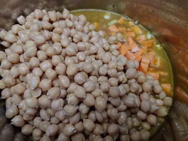 Chickpeas and broth added to pot.