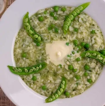 Instant Pot Pea and Mint Risotto in white bowl with glass of wine.