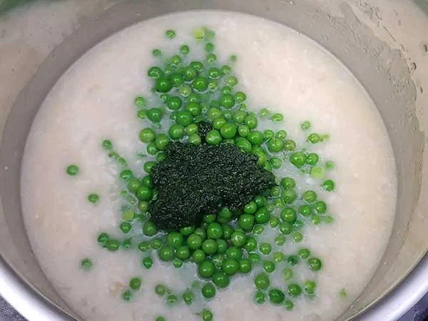 Fresh peas and mint on top of cooked rice and broth.
