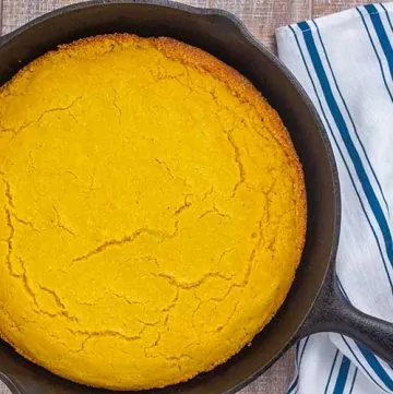 Cornbread in cast iron skillet with linen in background.
