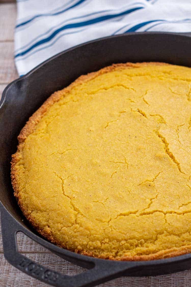 Cornbread in cast iron skillet with linen in background.