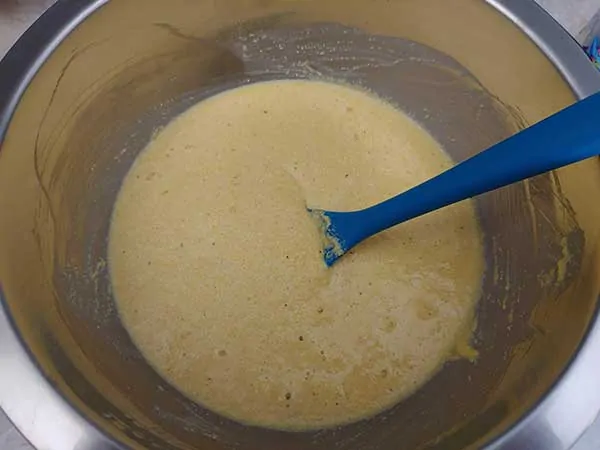 Cornbread batter in bowl with spatula.