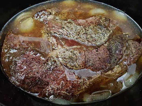 Pot roast in Crock Pot with onions.