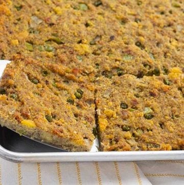 Southern Cornbread Dressing in sheet pan with spatula.