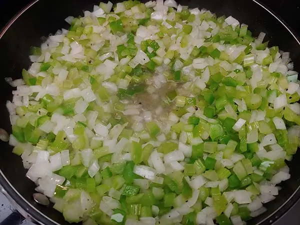 Sautéing onions, peppers, and celery in bacon fat.