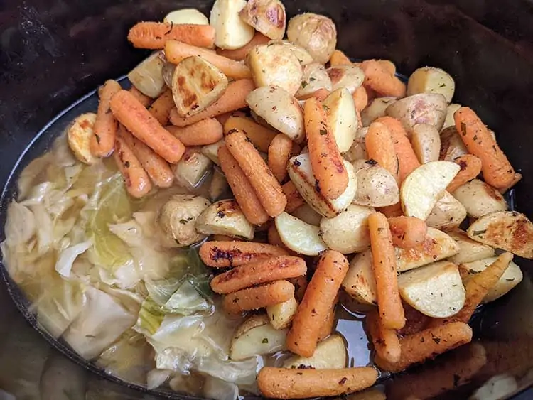 Potatoes and carrots in slow cooker with cabbage.