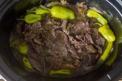 Whole30 slow cooker Mississippi pot roast with onions and pepperoncinis.