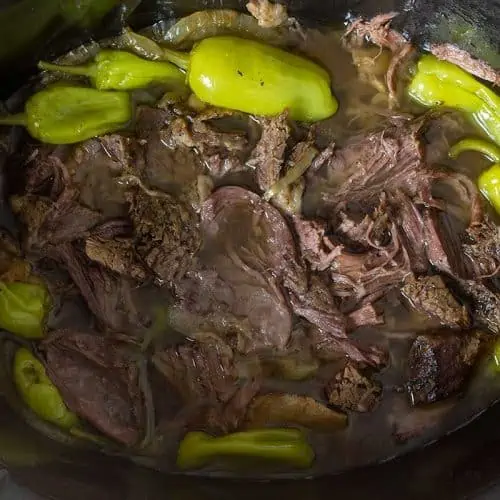 Whole30 slow cooker Mississippi pot roast with onions and pepperoncinis.