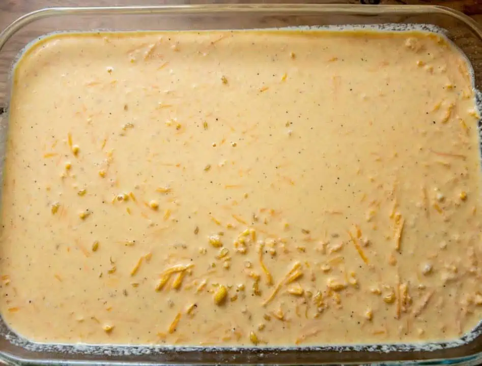 mixture of uncooked elbow noodles, shredded cheese, and milk in casserole dish