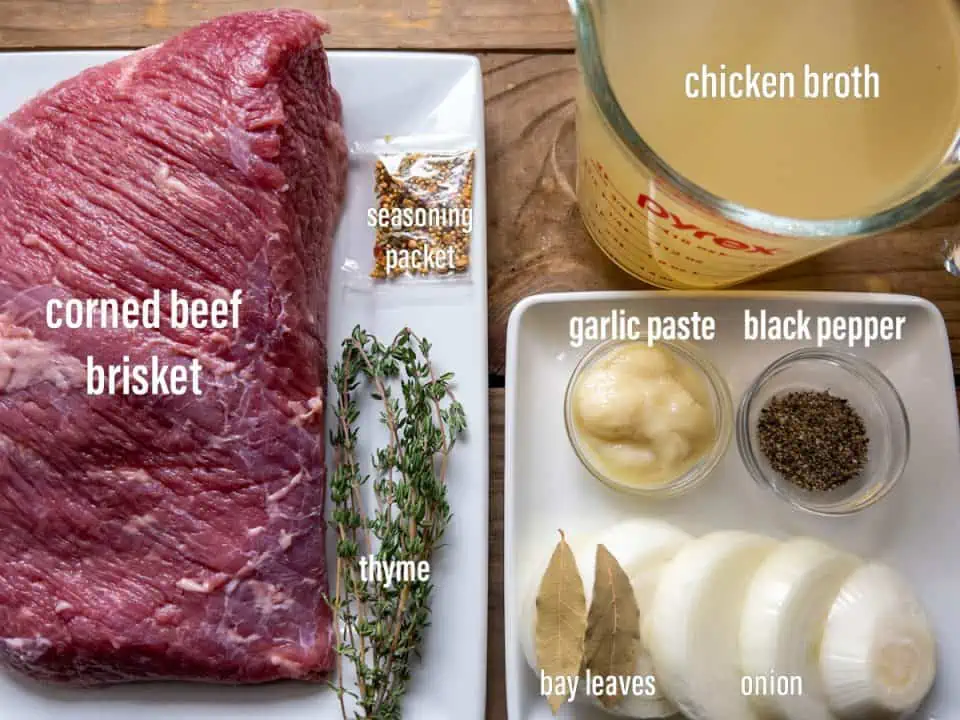ingredients for pressure cooker corned beef on white plates with a wood background
