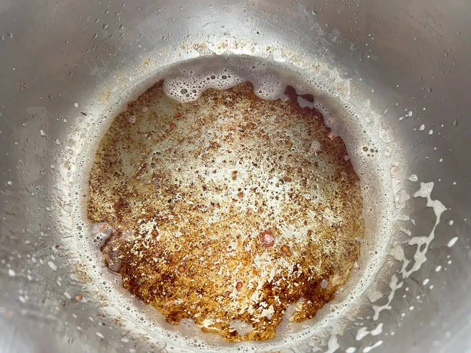 bottom of Instant Pot with rendered bacon fat and fond.