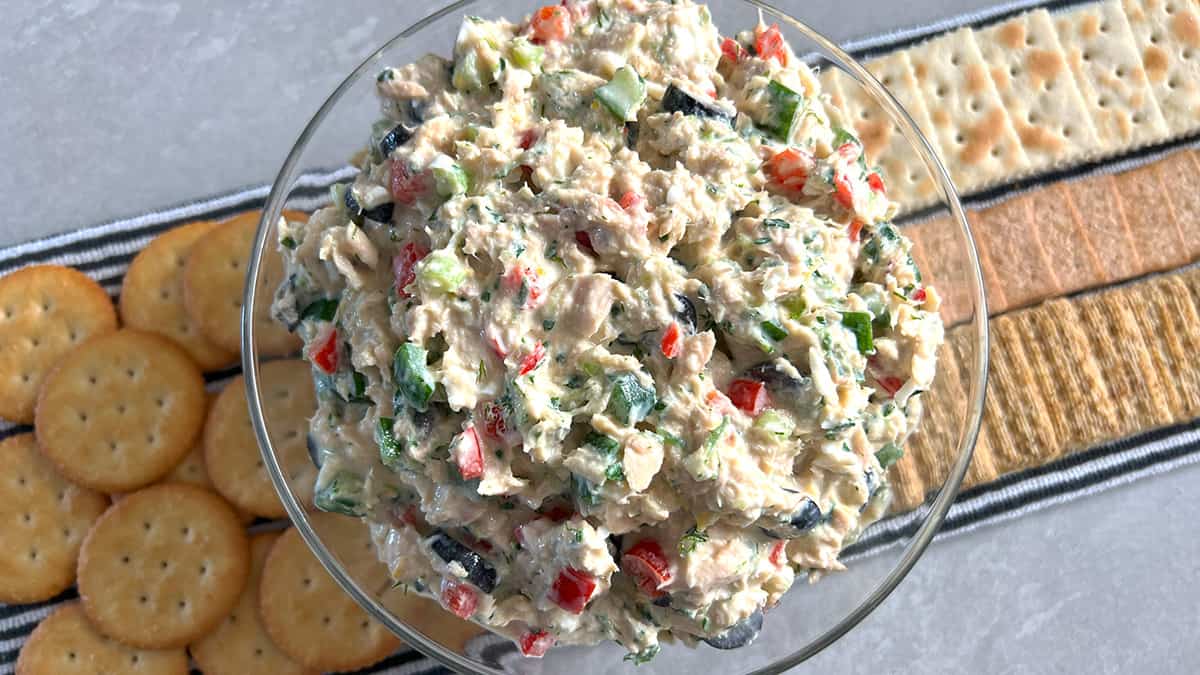 Bowl of Mediterranean tuna salad with different crackers behind.