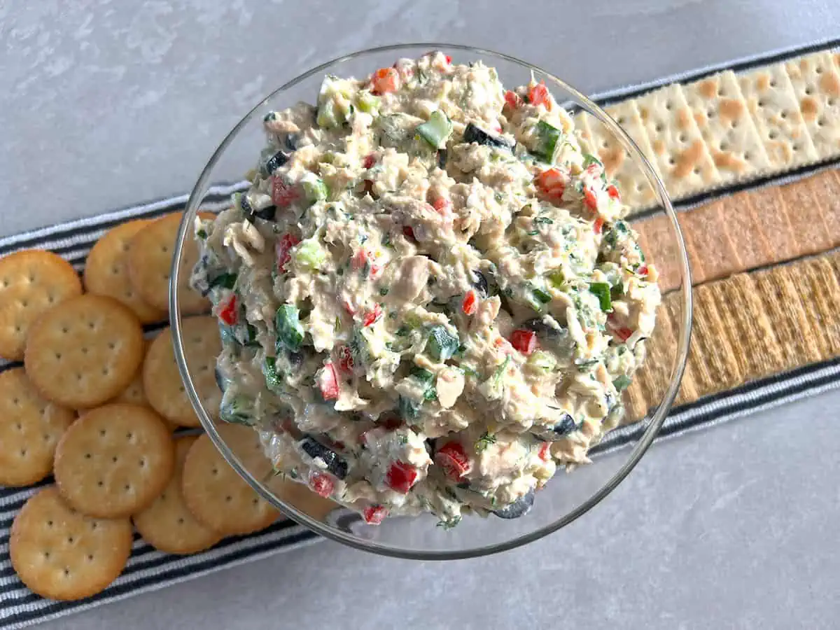 Bowl of Mediterranean tuna salad with different crackers behind.