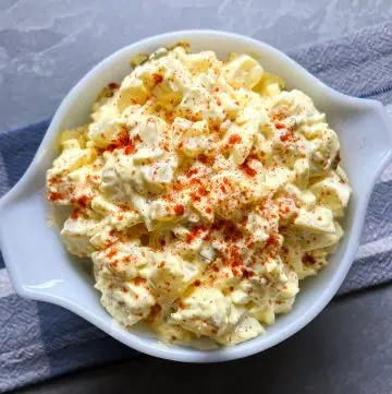 Instant Pot potato salad in a white bowl with a gray and blue background.