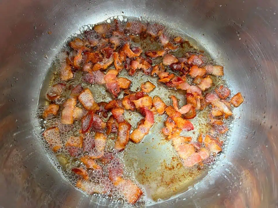 Crispy bacon pieces in bottom of an Instant Pot.