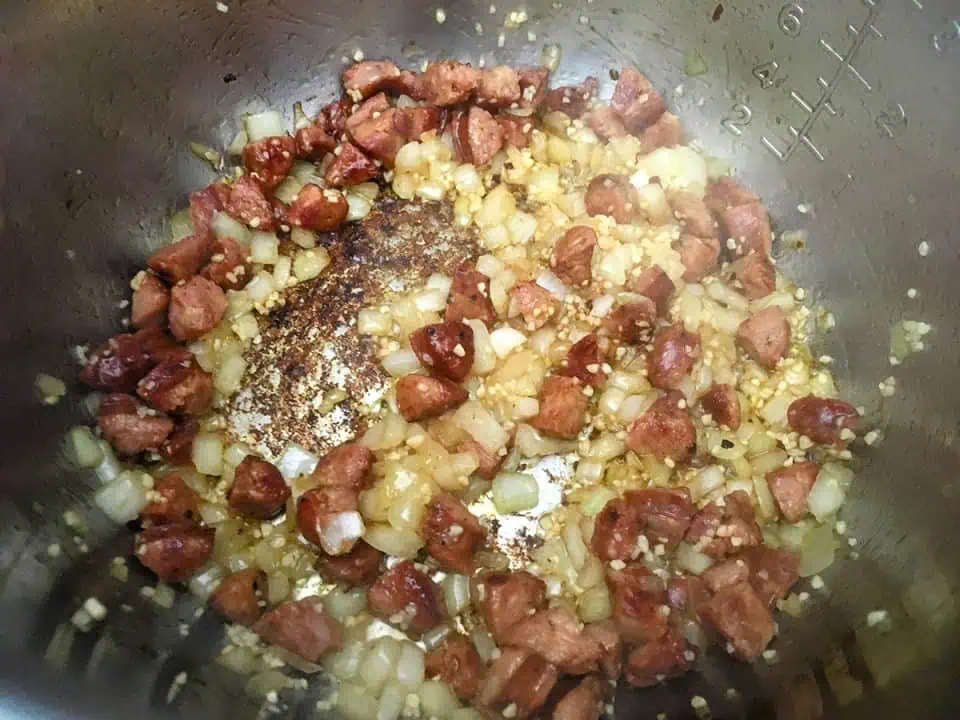 Sausage, onions, and garlic browning in pot.