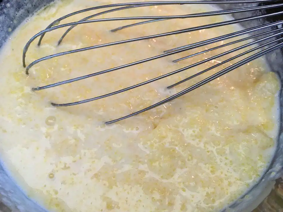 Bowl of grits with a whisk.