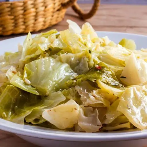 Instant Pot cabbage in white bowl with basket in background.