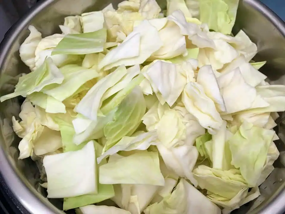 Uncooked cabbage filling an Instant Pot.