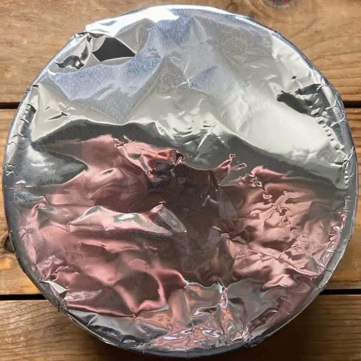 7-inch pan covered with aluminum foil on wood table.