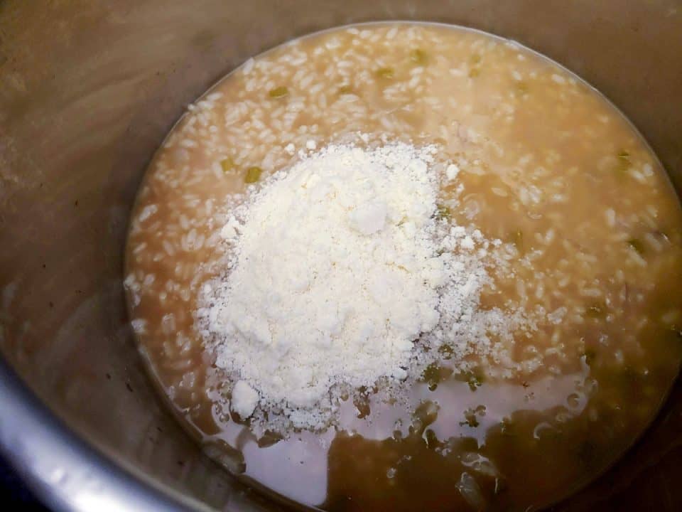 Risotto in pot topped with Parmesan cheese.