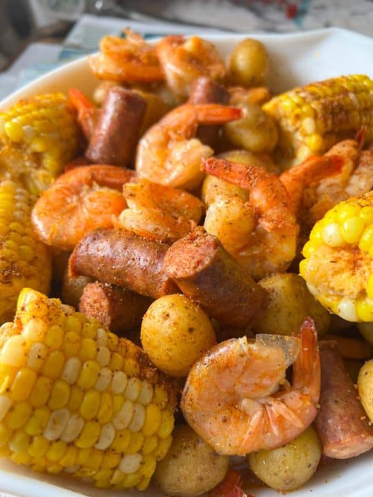 Instant Pot shrimp boil in large white bowl with newspaper background.