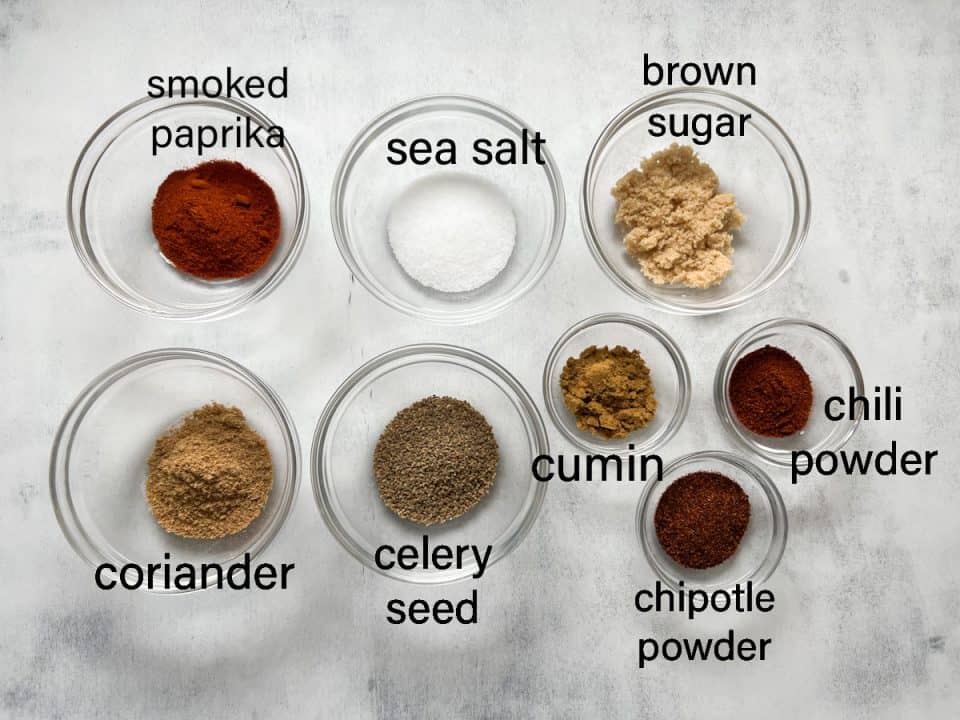 Ingredients for BBQ spice blend on white distressed background.