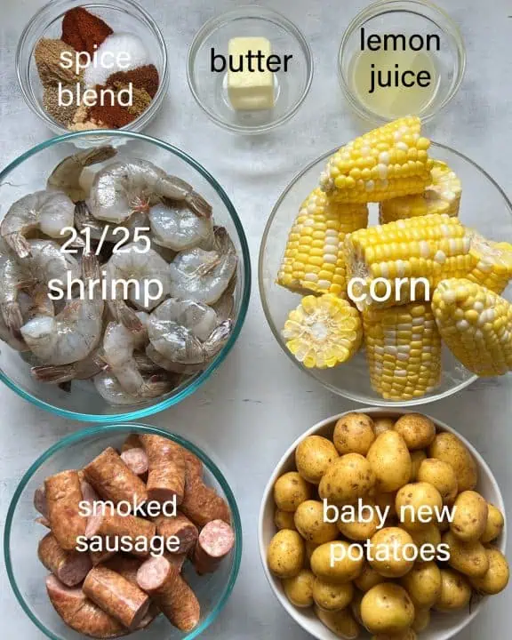 Ingredients for Instant Pot shrimp boil on white distressed background.