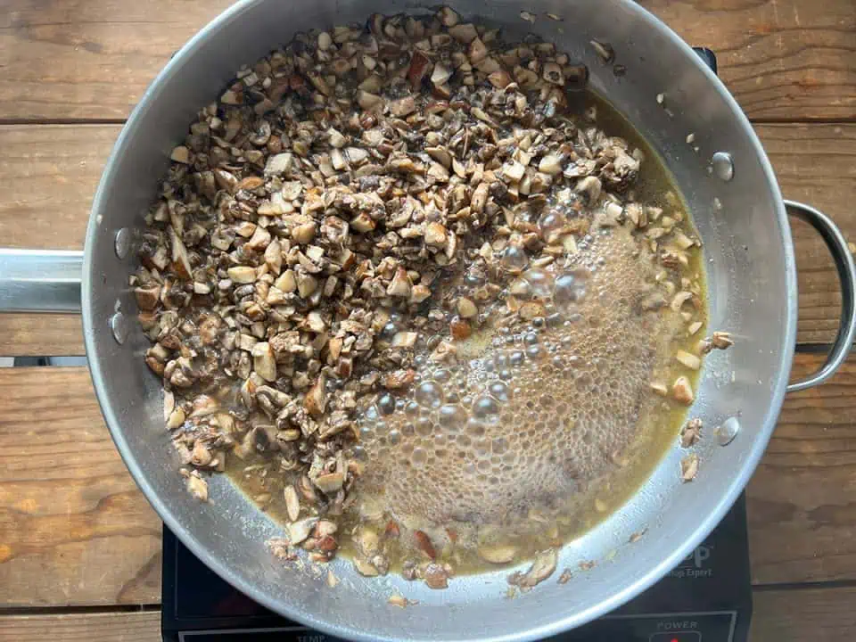 Sautéing mushrooms in large pan with lots of liquid.