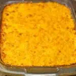 A casserole dish filled with baked mac and cheese with egg, showcasing a golden, bubbly texture on top.