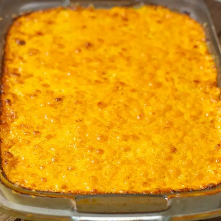 A casserole dish filled with baked mac and cheese with egg, showcasing a golden, bubbly texture on top.