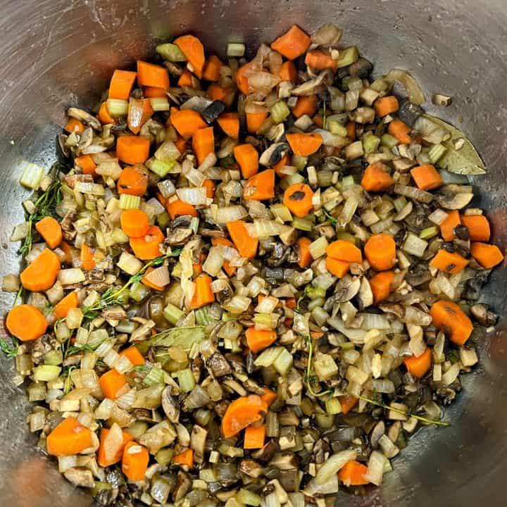 Sauteing a mix of vegetables in a stainless steel pot.