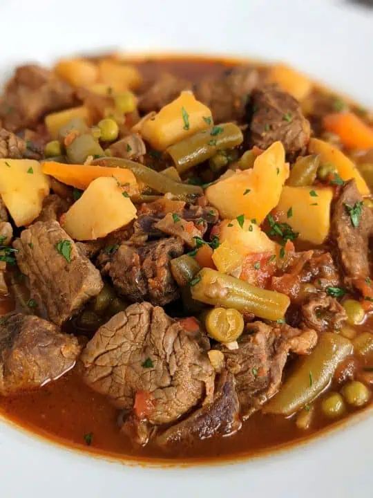 A white bowl full of Instant Pot vegetable beef soup.